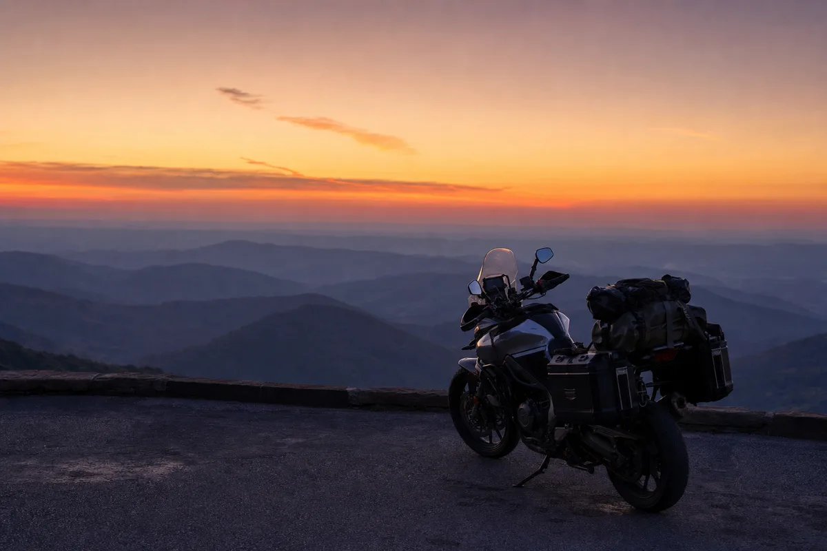 Moto de voyage à l&rsquo;arrêt sur une aire panoramique au crépuscule