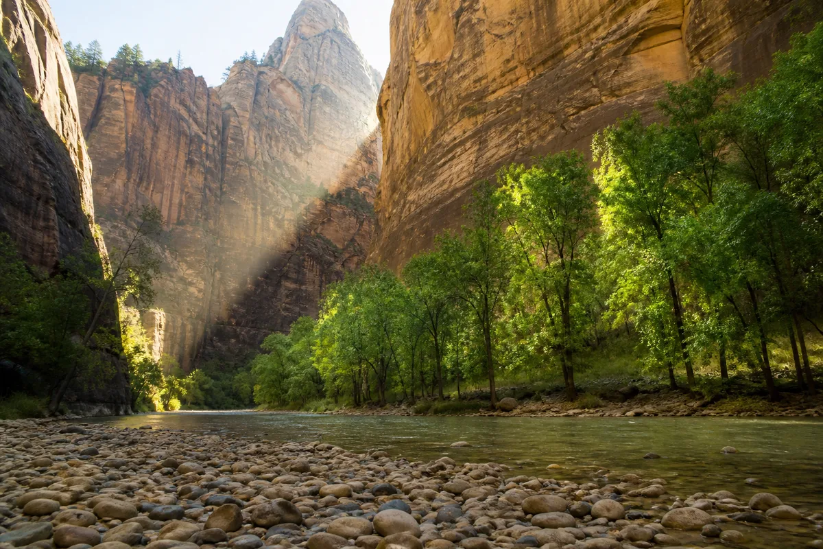 Parois de grès rayées dominant une rivière bordée de peupliers dans le canyon de Zion